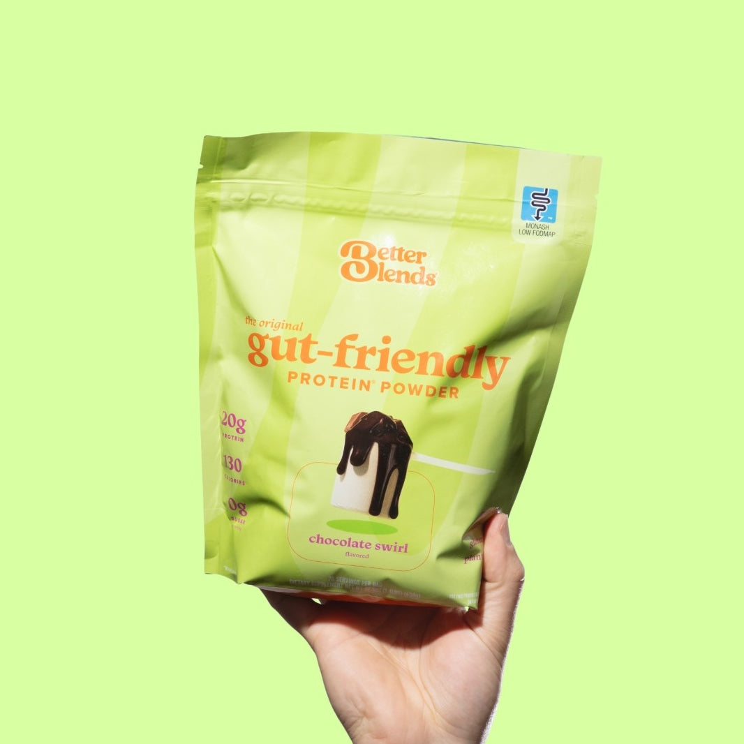 A hand holding up a bag of Chocolate Swirl protein powder