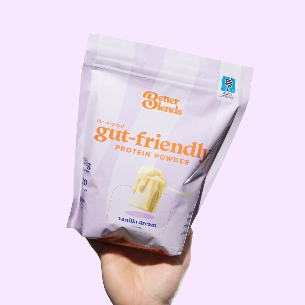 A hand holding up a bag of Vanilla Dream protein powder